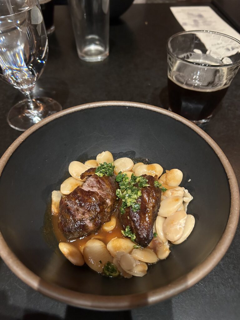 Porter-braised pork cheeks with glass of stout beer