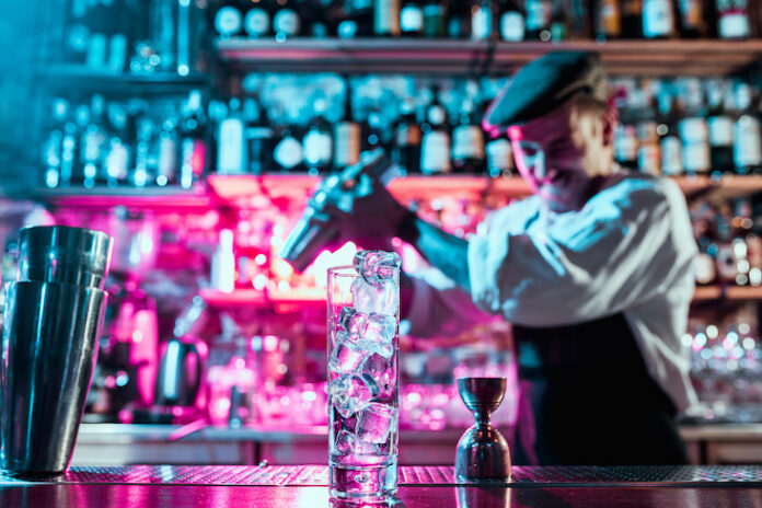 Expert barman is making cocktail at night club. bartender shaking cocktails