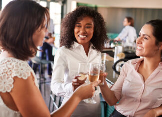 Three Businesswoman Meeting For After Works Drinks In Bar Making A Toast